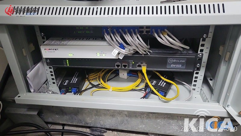 공장 통신랙 시공 후 — 노란색 광케이블과 흰색 LAN 케이블이 용도별로 깔끔하게 정리되어 체계적으로 장착된 완성 모습