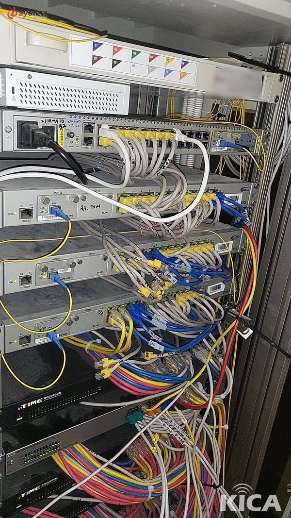 상단 FDF에서 하단 스위치 장비로 이어지는 광점퍼코드 배열 — 곡률 반경을 지키며 깔끔하게 정돈된 백본 연결