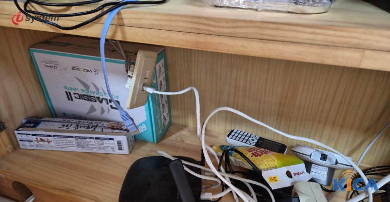 [설치 현장] 수납장 선반에 놓인 광모뎀과 공유기, 파란 UTP 케이블 연결 상태 - KT 기업인터넷 설치 현장