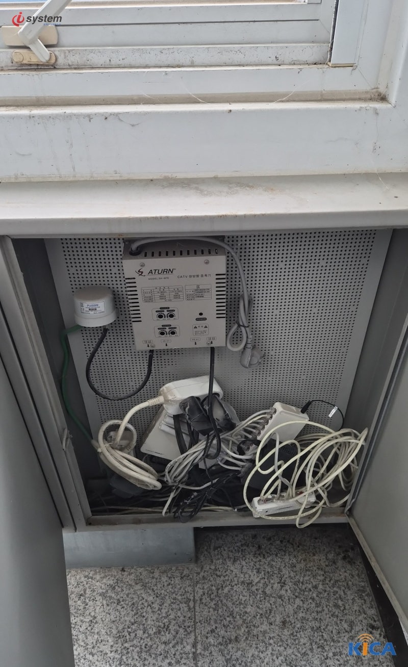통신단자함 내부에 설치된 증폭기와 분배 장비, 다양한 케이블이 함께 정리되어 있는 모습