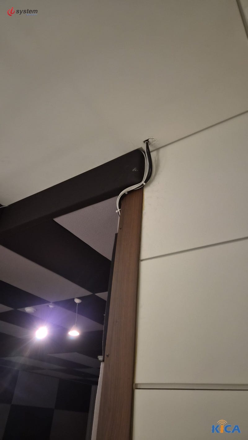 문틀 상부 천장 타공부로 인입되는 검은색과 백색 케이블