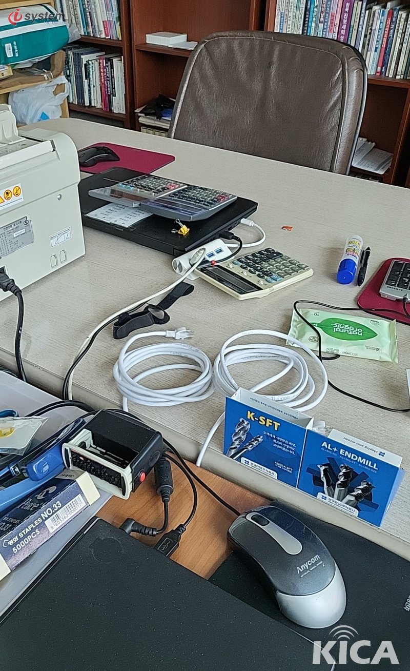 사무실 책상 위 노란 LAN 패치 케이블·멀티탭·계산기·금전등록기 — 시공 준비 단계