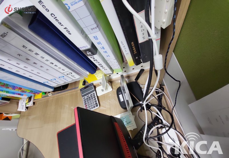 책상 위 Eco Clear File·정비내역서 폴더·계산기·노트북·USB 동글이 배치된 사무 작업 공간