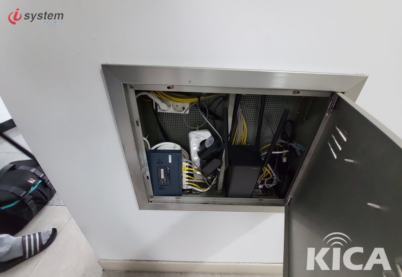 완성된 사무실 벽매립형 통신함 내부 — 무선 AP·노란 LAN 패치코드·미디어 컨버터가 체계적으로 정리된 모습